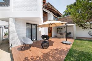 迪坡斯特兰Casa Naâmja的庭院配有遮阳伞、椅子和桌子。