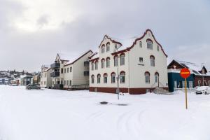 阿克雷里Hrimland Guesthouse的一条有房子和停车标志的雪覆盖的街道