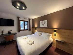朗巴克欧海姆巴赫酒店的一间卧室配有一张大床和两条毛巾