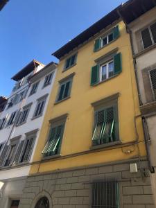 佛罗伦萨Dimora72的黄色建筑,设有绿色百叶窗