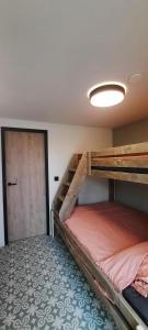 奥德纳尔德In 't Wiel Oudenaarde的一间卧室设有两张双层床和一扇门