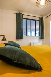 比尼克Escapade en Bord de mer avec Sauna et Spa Privés的一间卧室设有黄色的床和窗户。