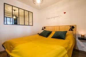 比尼克Escapade en Bord de mer avec Sauna et Spa Privés的卧室配有一张黄色的床,墙上有标志