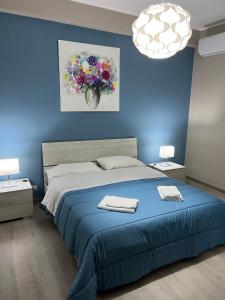 马斯卡利Casa vacanza Tropicana Home的蓝色卧室,配有带2条毛巾的床
