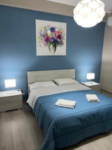 马斯卡利Casa vacanza Tropicana Home的一间蓝色卧室,配有一张床和两盏灯