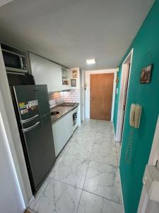 布宜诺斯艾利斯Apartment in Downtown Buenos Aires的一间厨房,配有绿色冰箱和瓷砖地板