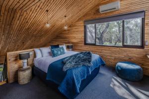 霍尔斯加普DULC小屋的小木屋内一间卧室,配有一张床和一个窗户