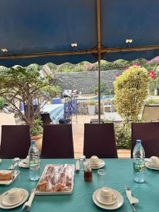 格雷岛Villa Charles - île de Gorée的一张蓝色桌子,上面放有食物和水瓶