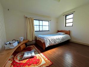 Kokubunji日久の宿的一间卧室设有床、窗户和地毯。
