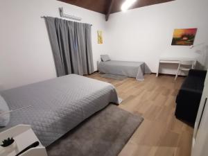 FelgarCasa d'Amêndoa的一间卧室配有两张床、一张桌子和一张沙发