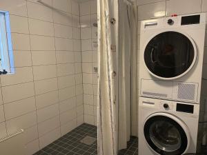 JärnaHoliday home JÄRNA II的浴室内配有洗衣机和洗衣机。