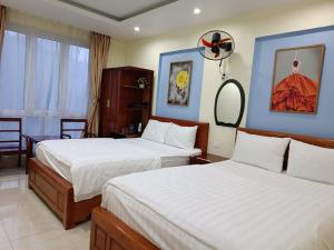 三岛县Khách sạn Anh Đào的酒店客房,设有两张床和镜子
