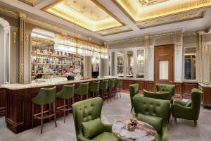 上海大都会海逸公寓的餐厅设有1间带绿色椅子的酒吧