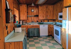 StrawberryCabin #5的厨房配有木制橱柜和白色家电
