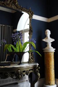 科克Flemings Country House的镜子和花瓶,桌子上布满紫色的花朵