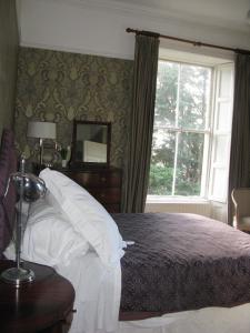 科克Flemings Country House的一间卧室设有一张大床和一个窗户。
