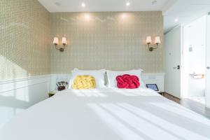 香港Tung Nam Lou Art Hotel的白色床上的两张彩色枕头