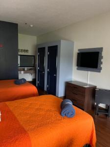 奥兰多奥兰治县国家高尔夫中心旅馆的酒店客房设有两张床和一台平面电视。