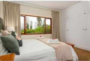 开普敦Valley Heights Guest House and B & B的卧室配有一张大白色床和窗户