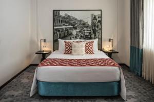 加尔各答加尔各答公园酒店的一间卧室配有一张大床和两张桌子