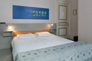 WittemHotel Beukenhorst的卧室配有一张带两个枕头的大白色床