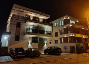 克卢日-纳波卡SarmiHouse的两辆汽车晚上停在大楼前