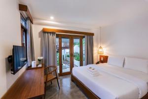 攀牙Phang Nga Origin Hotel的卧室配有一张白色大床和电视。