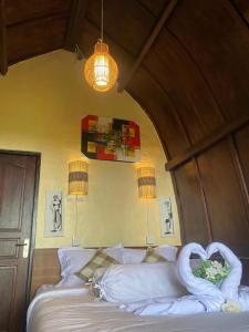 GitgitPondok Ganesha Bali的一间卧室配有一张带天鹅的床
