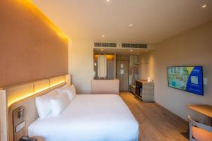 乌汶Centara Ubon的一间酒店客房,配有一张床和一台电视