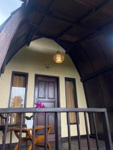 GitgitPondok Ganesha Bali的门廊配有桌椅和门