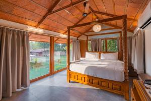 海得拉巴Brown Town Resort & Spa的一间卧室设有一张床和一个大窗户