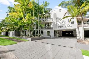 努萨维尔努沙康纳酒店的一座白色的大建筑,前面有棕榈树
