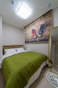 大田Comma的一间卧室配有一张带绿毯的床