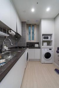 大田Comma的厨房配有水槽和洗衣机