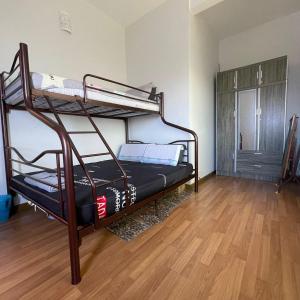 适耕庄Countryside Condo @One Residence Sekinchan的客房设有两张双层床,铺有木地板。