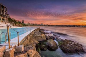 悉尼Spirit of Bondi Apartments的日落时分享有海滩和大海的景致