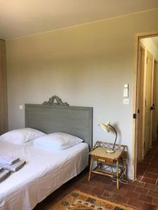 格里莫Villa neuve et moderne avec piscine à Grimaud的一间卧室配有两张床和一张带台灯的桌子