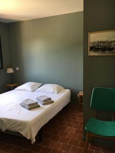 格里莫Villa neuve et moderne avec piscine à Grimaud的一间卧室配有一张床和一把绿色椅子