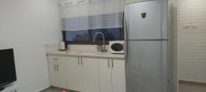 Beʼer Oraפינה קטנה בערבה的白色的厨房配有冰箱和水槽