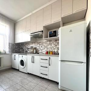 奥什ABS Guest House Osh的厨房配有白色橱柜、洗衣机和烘干机
