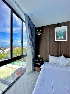 昆岛Tuấn Ninh Hotel II的一间卧室设有一张床和一个大窗户