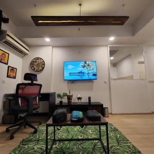 勒克瑙The Nest Lucknow的客厅配有椅子和墙上的电视