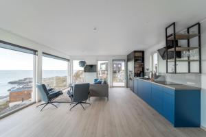 RundeRunde Panorama - Trollvogga的一间设有蓝色橱柜的厨房,享有海景