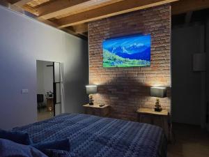 吕本瑙Spreewaldhaus Widwan的卧室配有1张床和1台砖墙电视