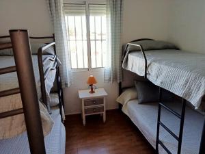 CampanoCasa rural El Limonero的一间卧室设有两张双层床和一扇窗户。