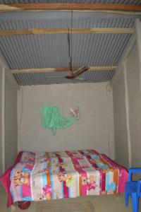 Bhada Community Homestay的一间带一张床铺的卧室,位于带天花板的房间内