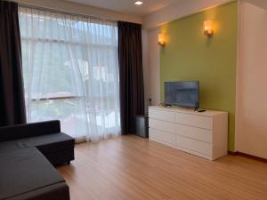 亚依淡Deview Hotel Penang的带沙发的客厅和梳妆台上的电视
