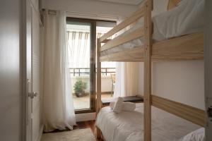 扎鲁亚斯MENDILAUTA的一间带两张双层床的卧室和一个阳台
