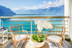 蒙特勒Montreux paradise top view的阳台配有两把椅子和一张桌子,种植了植物