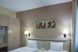 迪拜West Zone Pearl Hotel Apartment的酒店客房设有两张床和两盏灯。